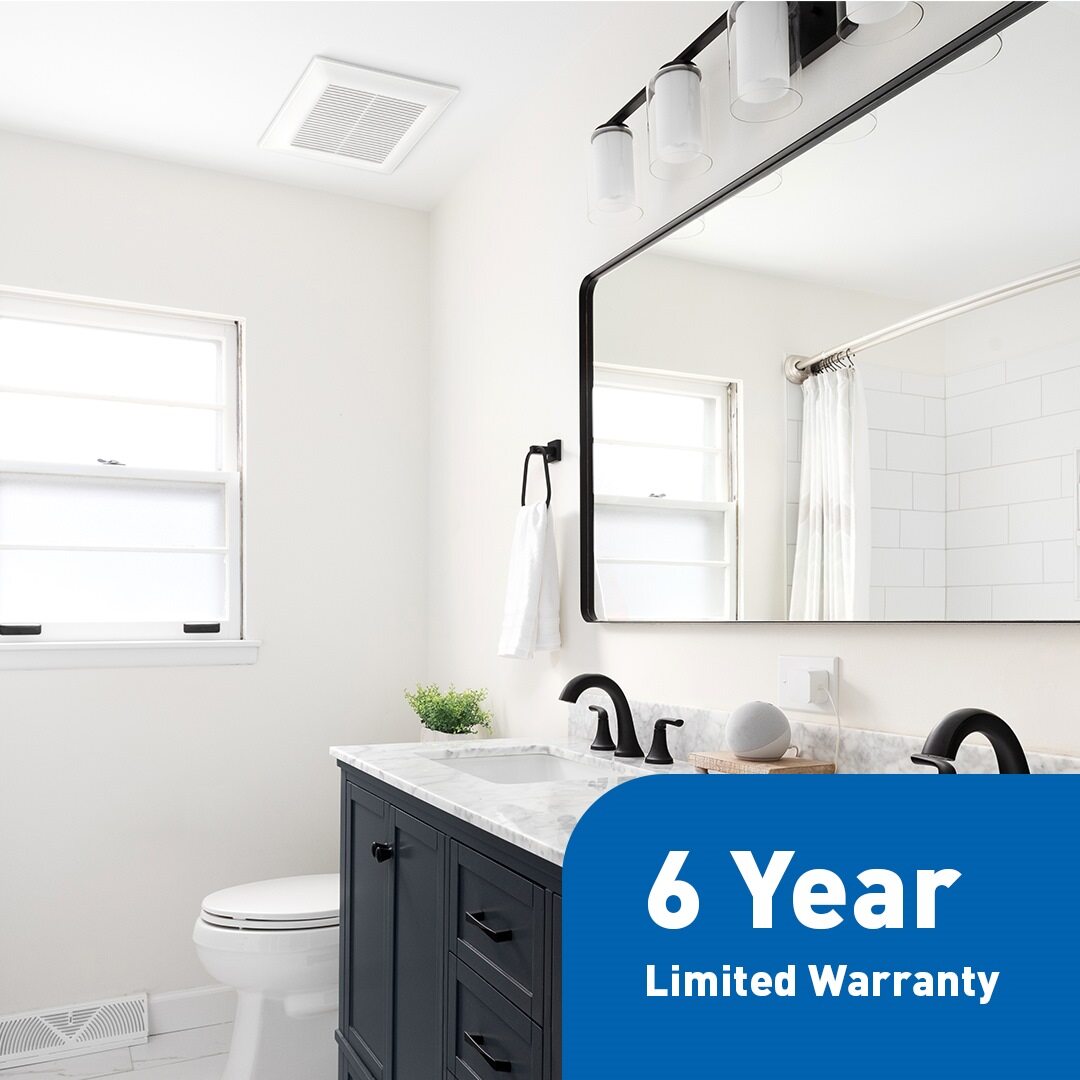 Installed Panasonic ventilation fan on bathroom ceiling with 6-year limited warranty badge shown in foreground.